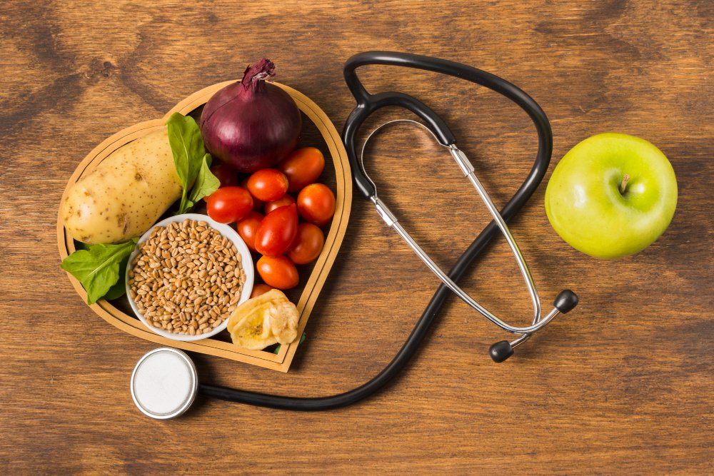 a heart shaped bowl with vegetables and a stethoscope